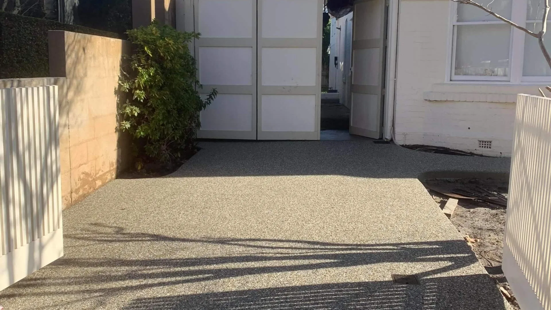 Exposed aggregate driveway repaired and restored in front of a Melbourne garage
