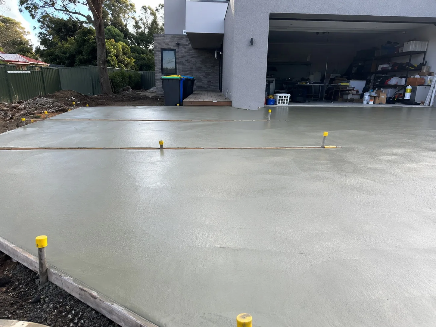 Newly installed concrete driveway and apron in front of a Melbourne garage