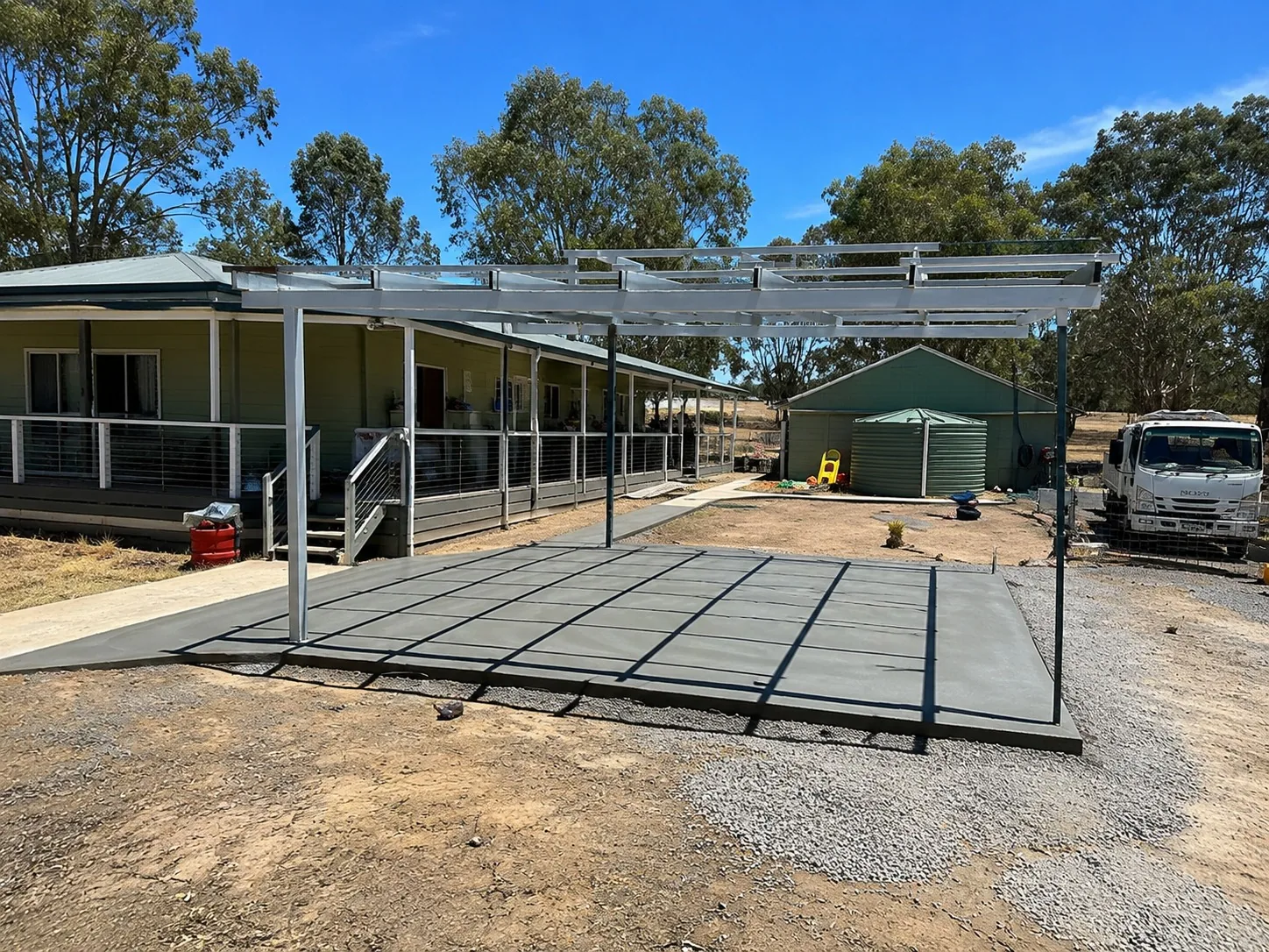 Steel shed frame going up on a prepared slab and compacted gravel pad