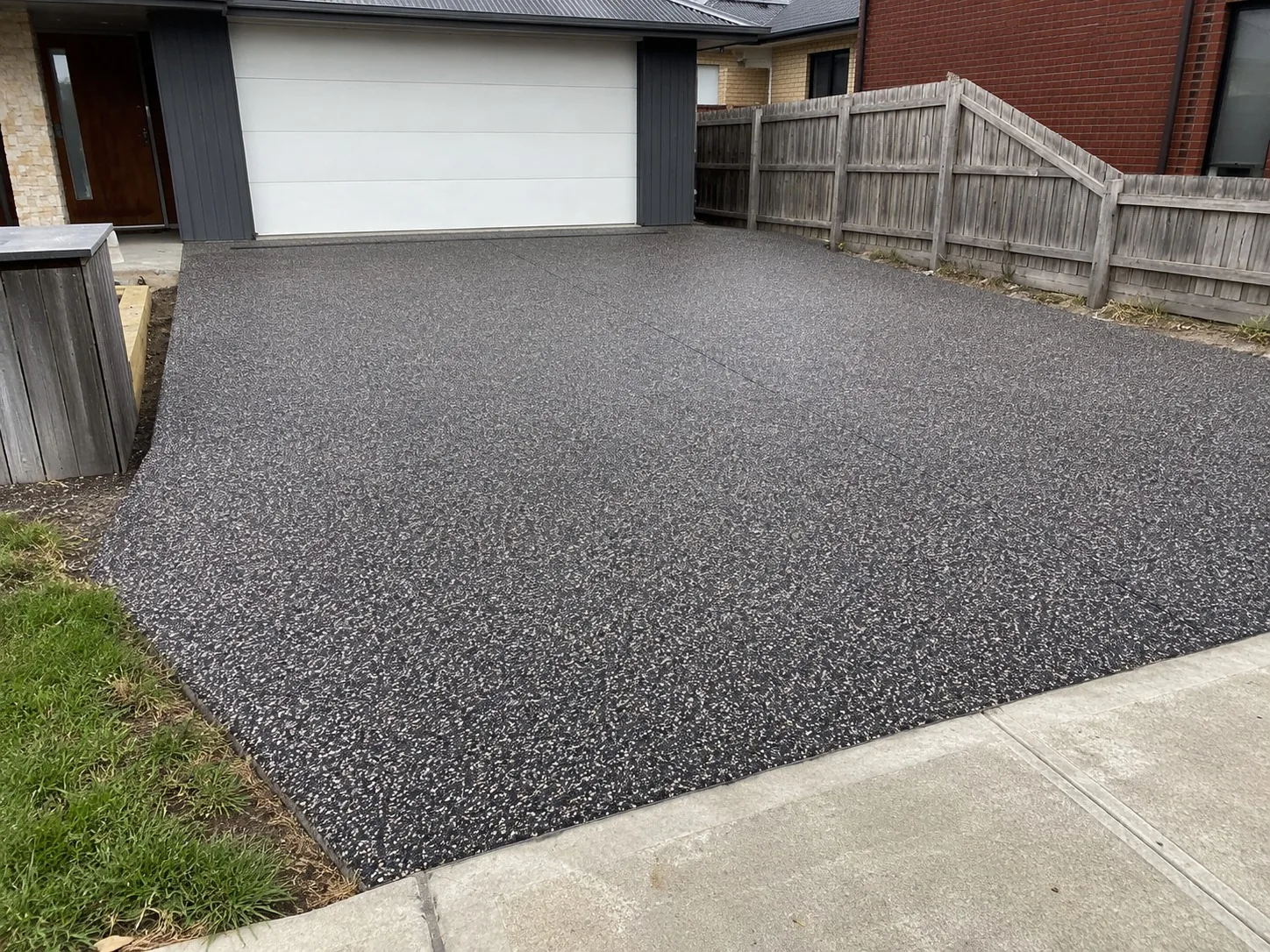 Exposed aggregate driveway extension running to a Melbourne garage door