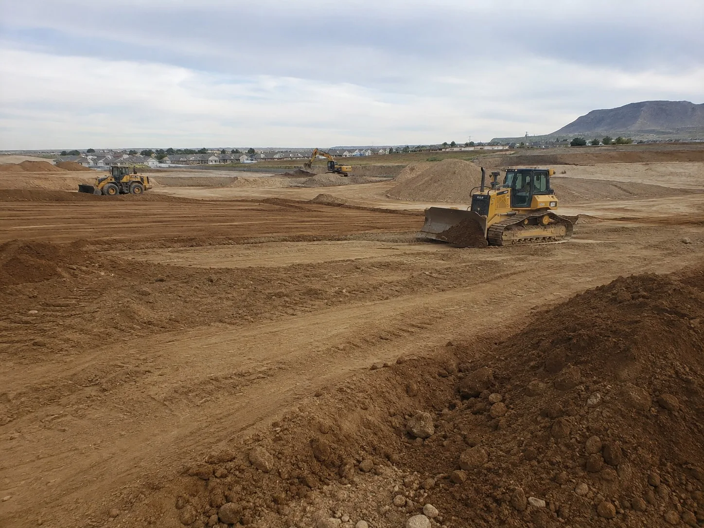 Bulldozer cutting and grading a large open site to level