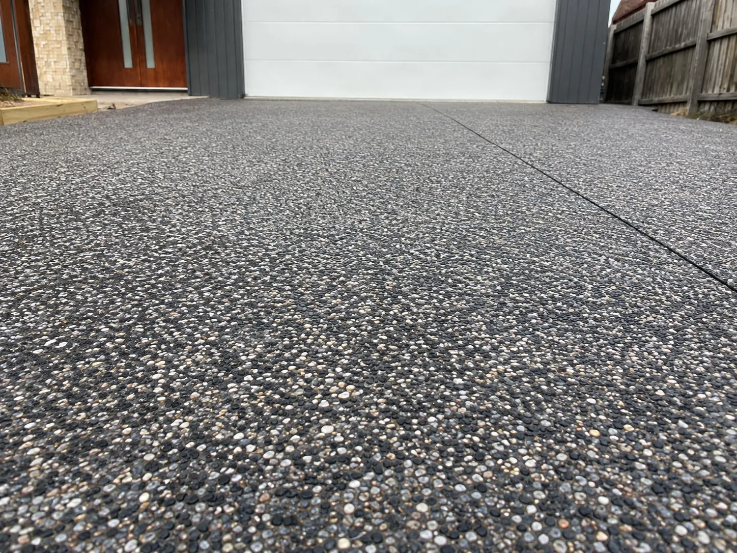 Charcoal exposed aggregate driveway running to the garage of a Melbourne home