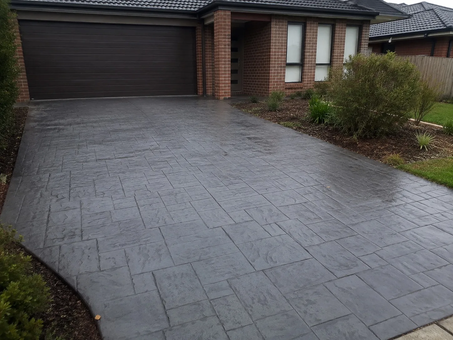 Slate-pattern stamped concrete driveway at a brick Melbourne home